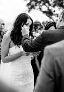 groom wiping tears of crying bride